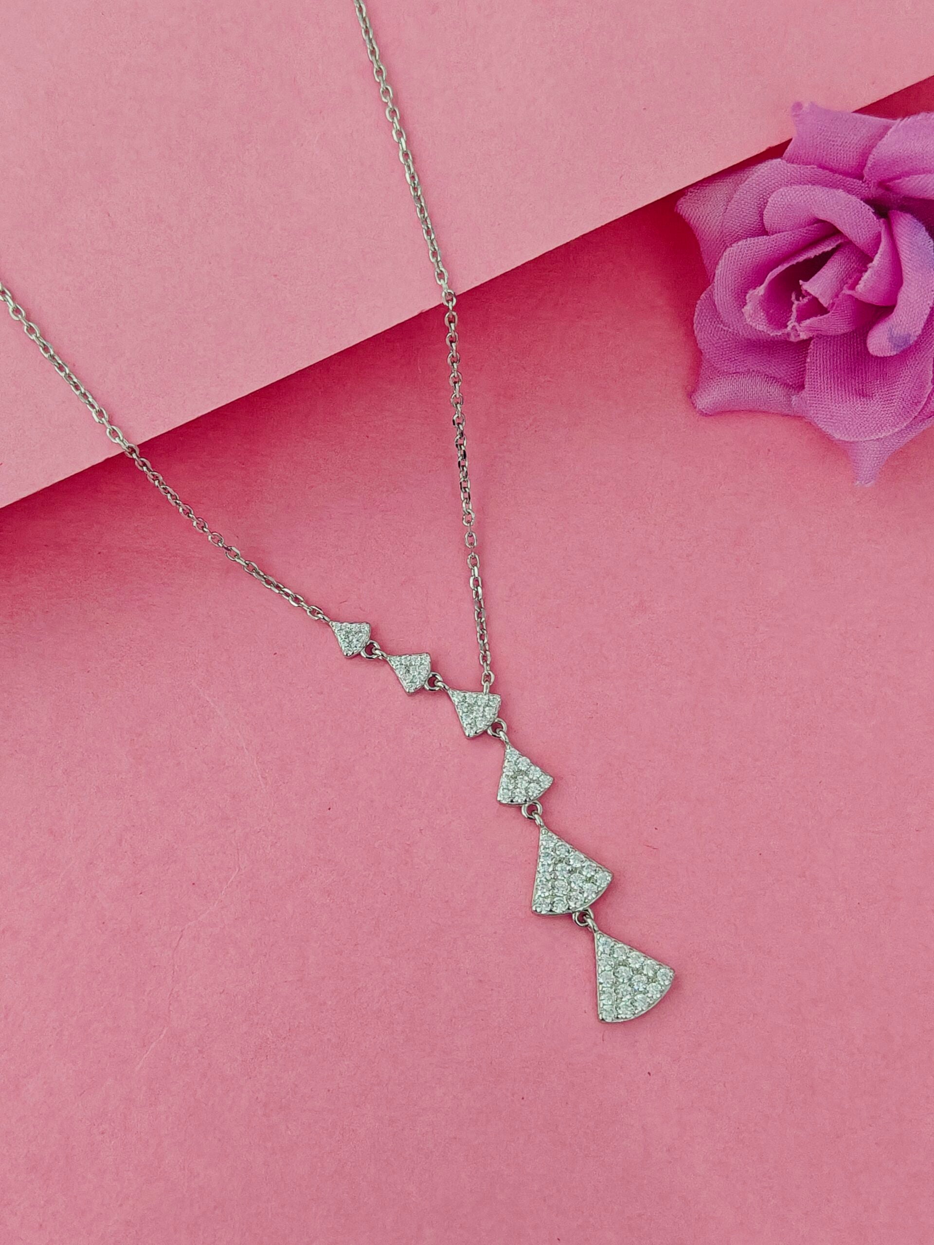 Necklace with heart-shaped pendants on a pink background